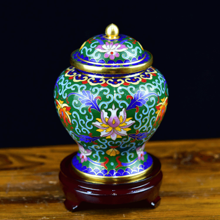 Decorative ceramic jar with floral patterns on a wooden stand against a dark background