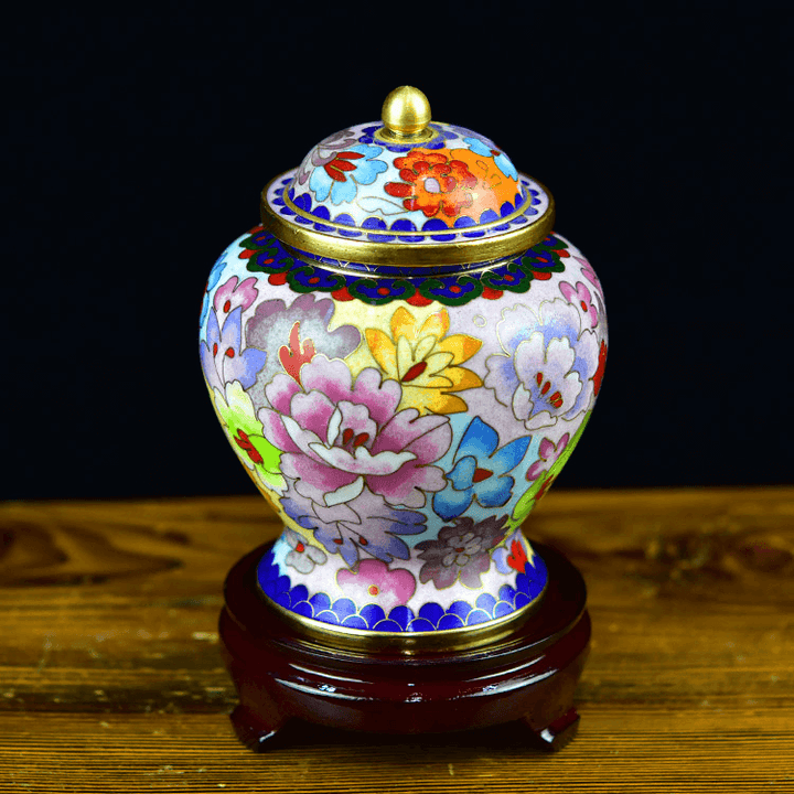 Decorative Urn with floral patterns on a wooden stand against a dark background