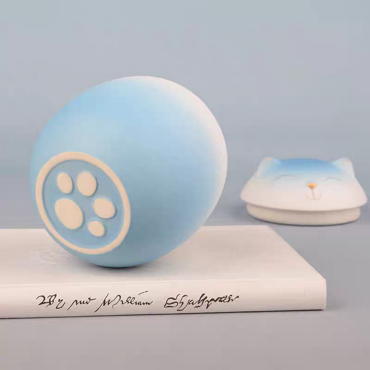 Light blue ball with paw print design on a gray background