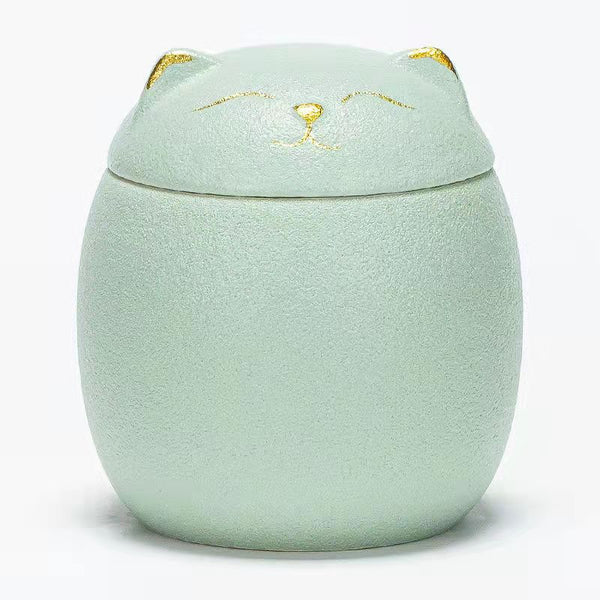 Mint green cat-shaped container with a lid on a white background