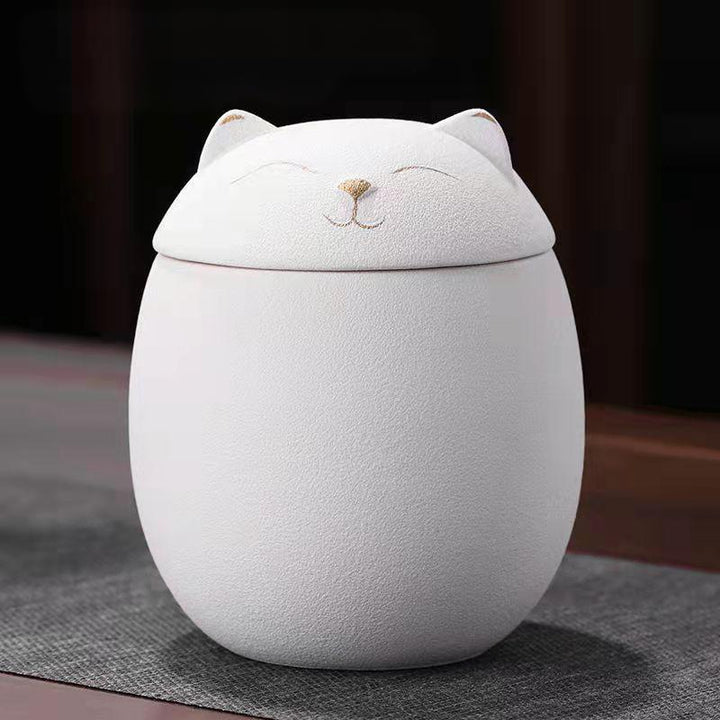White ceramic urn with cat design on lid